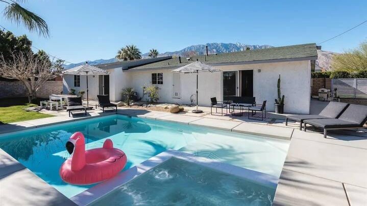 pool house with pink flamingo on the pool in a sunny day