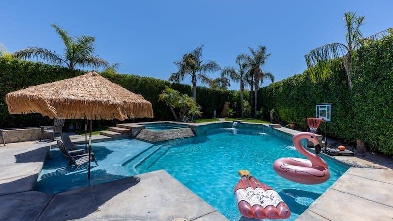 Pool with tiki umbrella and flamingo floatie