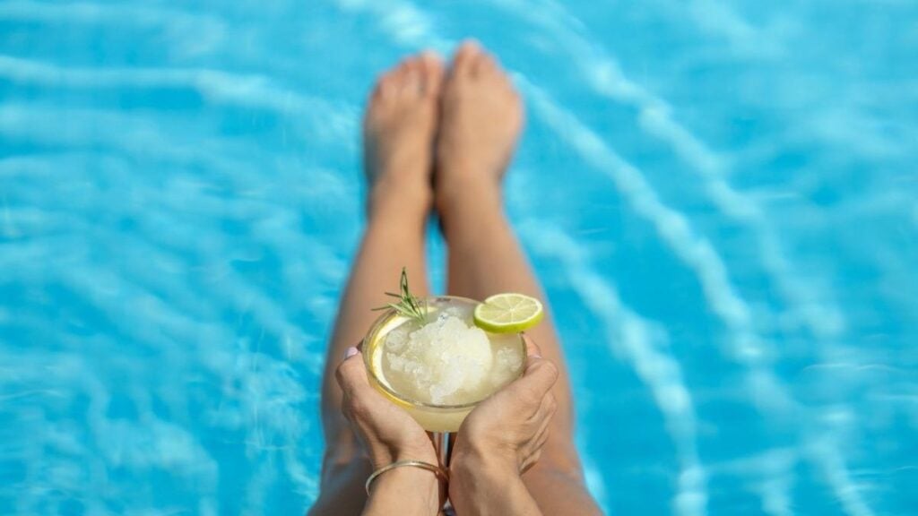 margarita drinking while soaking sunlight in the pool