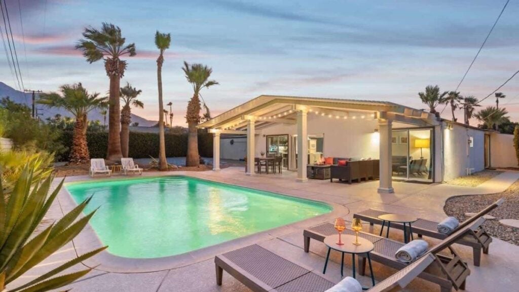 poolside sun beds with palm trees on the back