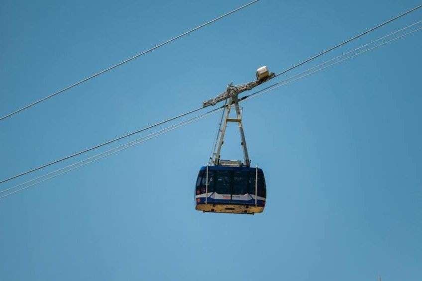 yellow blue 6 white cable car with clear blue skies on the back