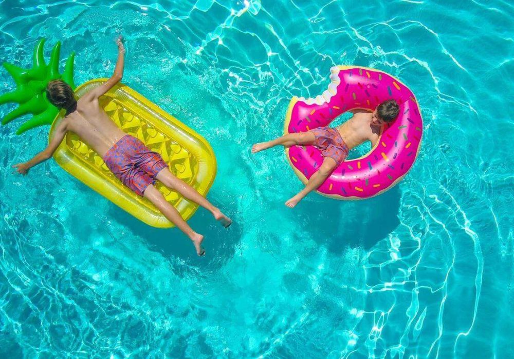 kids on floats laying down over the pool